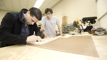 Photo by Sean Weaver/NMHU Media arts students Daniel Atencio, left, and Joe Weber construct a display for “Fashioning New Mexico,” one of the inaugural exhibits for the New Mexico History Museum.