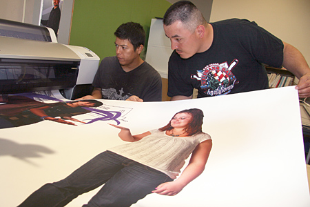  Photo Margaret McKinney/Highlands University Highlands University Media Arts Students Joey Montoya, left, and Leonard Lucero check the quality of a banner being printed for the April 21 President’s Gala: Dollars For Scholars. The students are in a Surround Sound and Installation class that is creating multimedia projects for the gala.