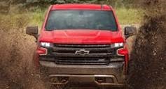 image of red Chevy driving through mud