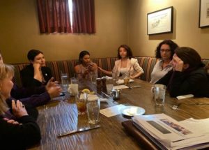 Photo of several students and professors at table.