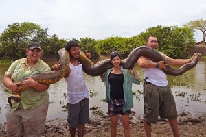 four students holding an Anaconda