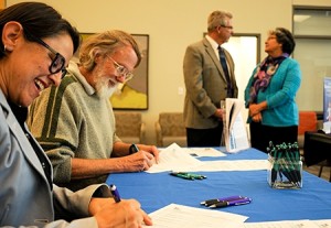 Photo of Two faculty members signing documents.