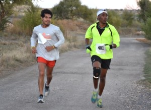 two athletes running on road