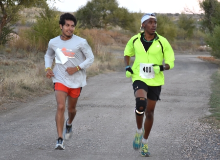 Highlands University student Simelane Siphamandla, right, wins first place at the university’s Out of the Darkness 5K run for domestic violence awareness Oct. 27 at the Gene Torres Golf Course. Siphamandla is a graduate student in media art’s software-driven systems design program. Omar Cortes, left, a criminal justice senior who runs cross country for the Cowboys, ran to pace the leader on the course and support HU-CARES, the race organizer. Other sponsors for the run included the Tri-County Family Justice Center, the 4th Judicial District Attorney’s Office, and the Highlands Student Senate. Photo by Margaret McKinney/Highlands University