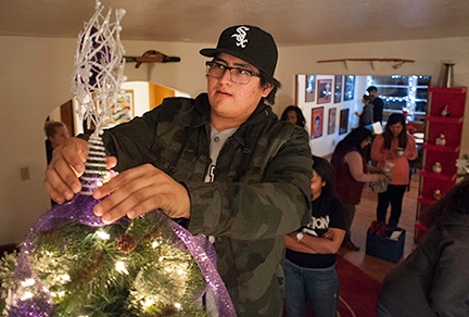 Checho Izaguirre, a Highlands junior majoring in Spanish and media arts, puts the final touch on a holiday tree at the university’s President’s House Dec. 1. Highlands President Sam Minner and his wife Joan invited students from the university’s International Club, Native American Club, MEChA, the NMHU Ambassadors, and the Student Athlete Advisory Committee for an evening of holiday tree decorating, hot chocolate and cookies. Photo by Sean Weaver/NMHU