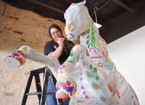 Photo: Margaret McKinney/Highlands University Janel Herrera was among the Highlands University students and faculty who volunteered Sept. 16 to paint a Cowboy horse for a public art project for homecoming. Herrera is a senior media arts major from La Jara, New Mexico