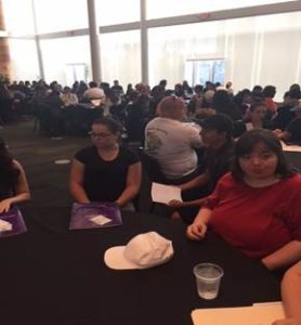 Photo of students sitting at tables in ballroom.