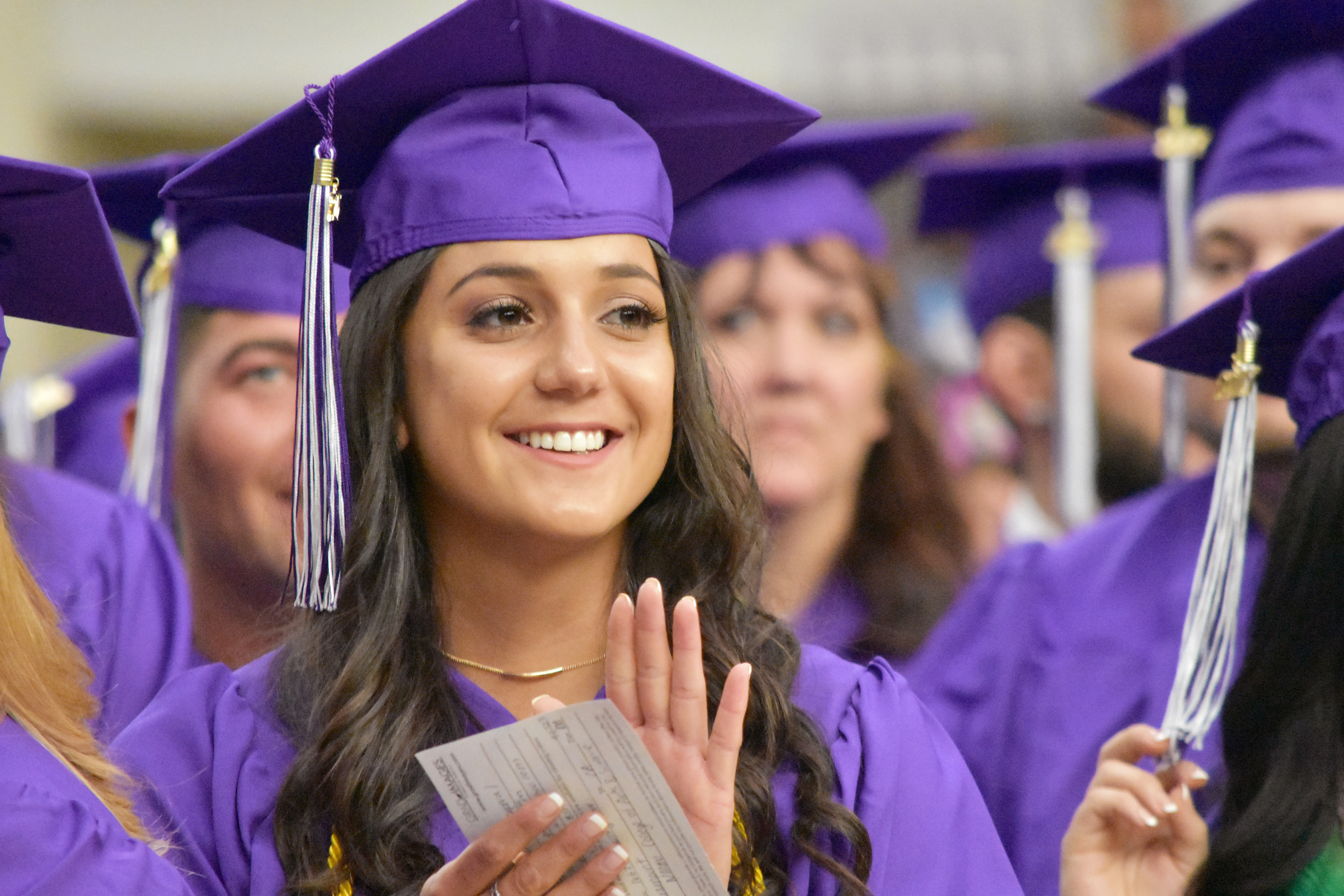 Photo of group of new graduates, with a young woman in the foreground.