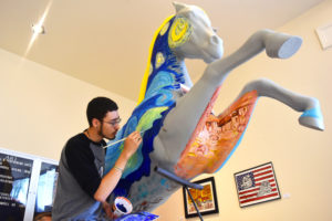 Photo of student painting the Highlands Homecoming Horse