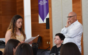 Photo of student reading her essay to the class.