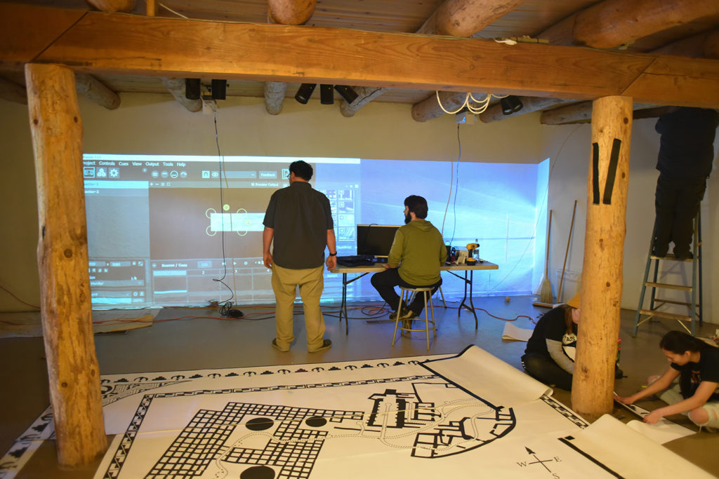 Photo of Independent video artist and consultant Morgan Barnard, left, helping student Stephen Snyder align the projection display.