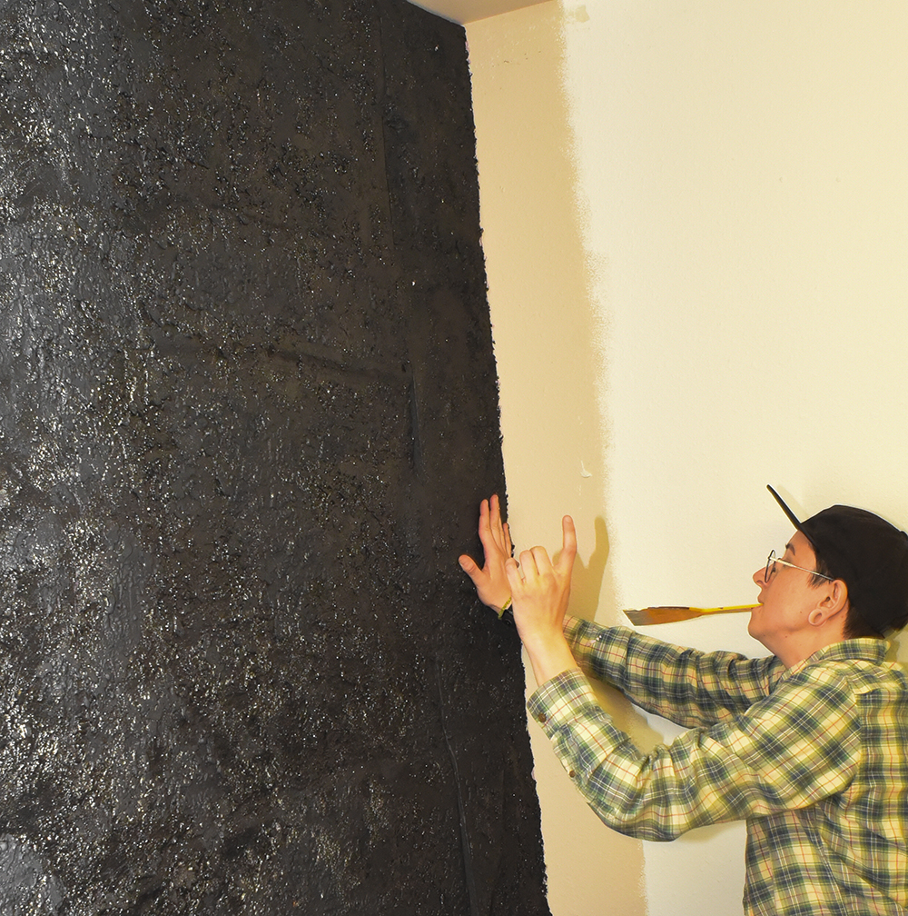 Photo of student placing panel against a wall.