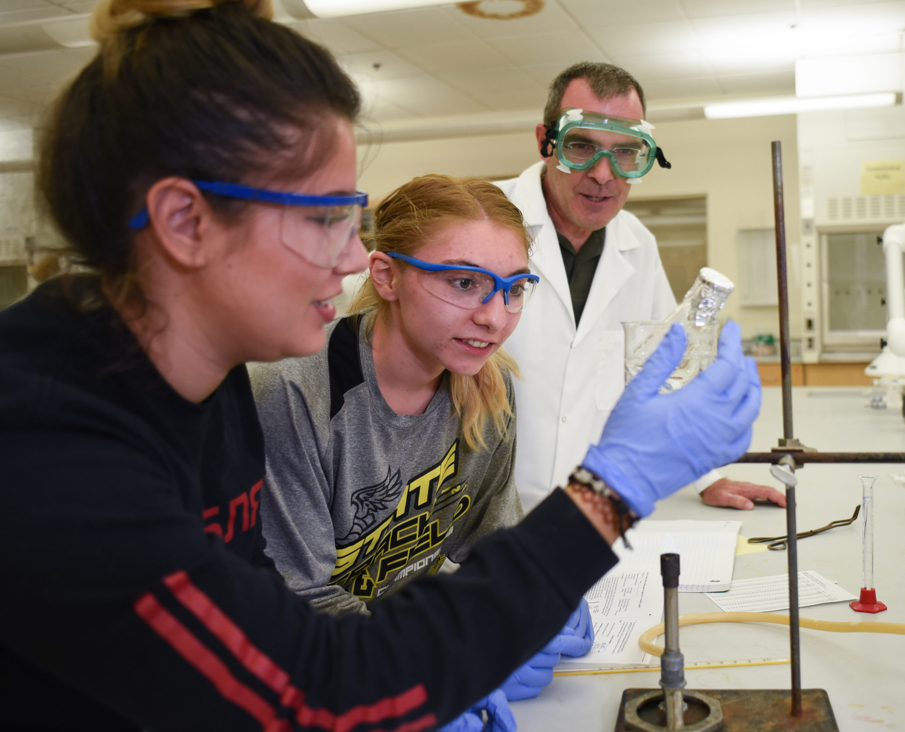 Photo of chemistry students and a professor conducting an experiment.
