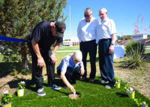 Photo of Ann Gibson placing her late husband Don's ashes.