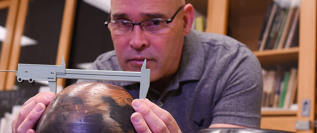 man measuring artifact