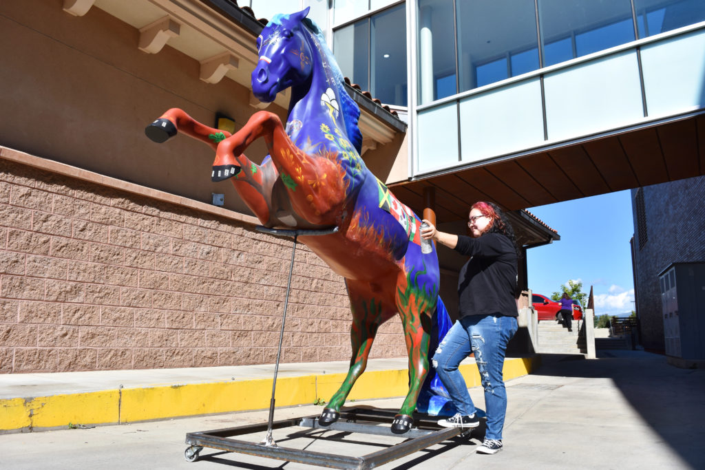 Photo of student painting the Homecoming Horse