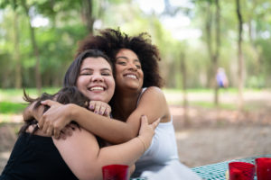 Two Friends Embracing at Picnic Party