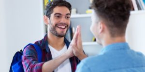 Photo of two college students high-fiving.
