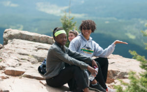 Photo of three students enjoying the view atop Hermit's Peak.