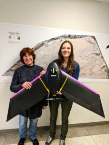 Photo of two instructors holding a large drone.