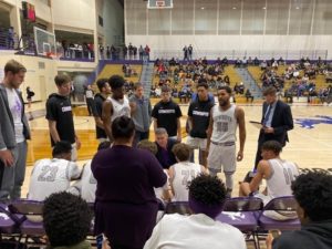 Image of Coach Dominguez drawing up a play with the team.