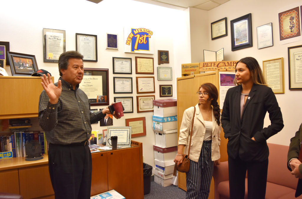 Photo of Senator Campos speaking with two students.