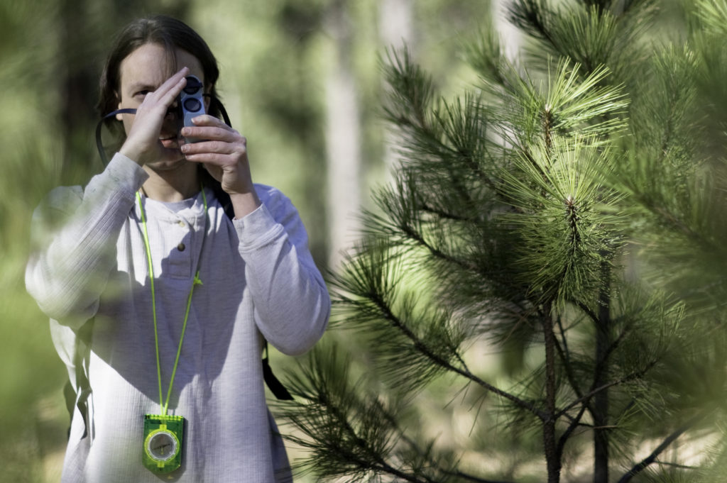 Photo: A Highlands University forestry student takes forest management measurements during fieldwork.