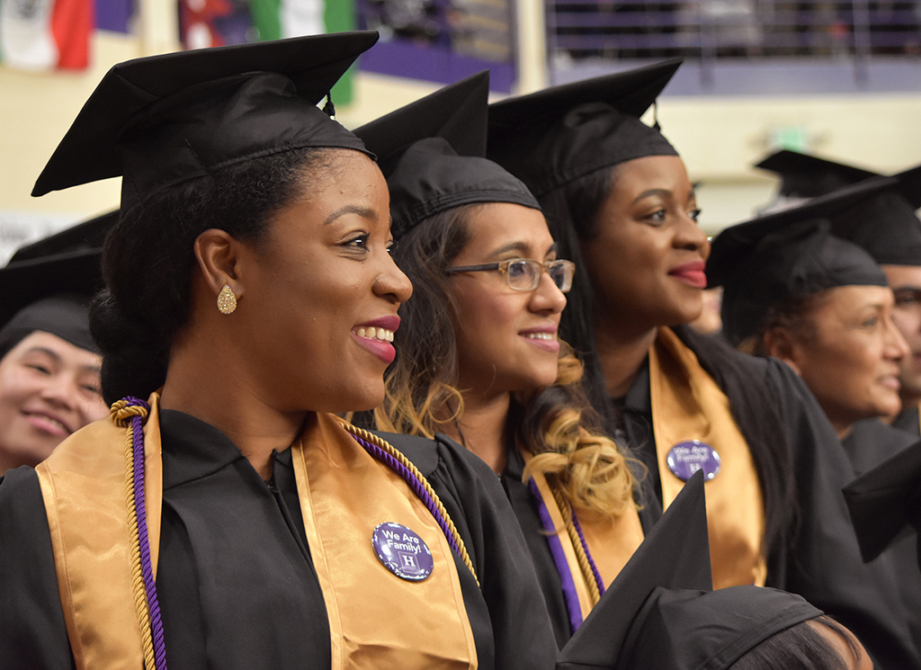 A row of recent graduates smiles.