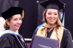 Photo of Provost awarding diploma to graduate student.