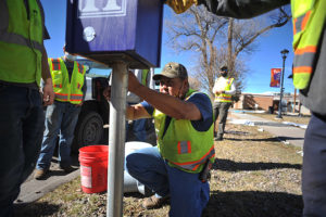 Highlands University carpenter Miguel Griego installs the first of three little free library boxes at the university’s Melody Park Feb. 23.  Photo: Sean Weaver, University Relations