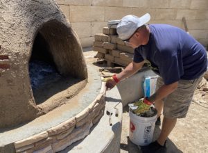 Photo of worker adding cement to the new horno