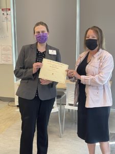 Valerie Nye and April Kent pose in masks with Academic Librarian of the Year Award. 