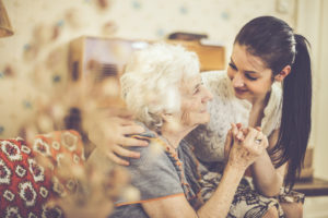 Social Worker embracing elderly woman