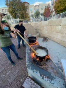 Two students tend to boiling pots over open fires at the Matanza