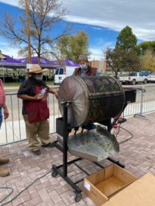 Photo of cook standing next to chile roaster