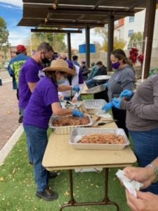 photo of people picking up food from long table