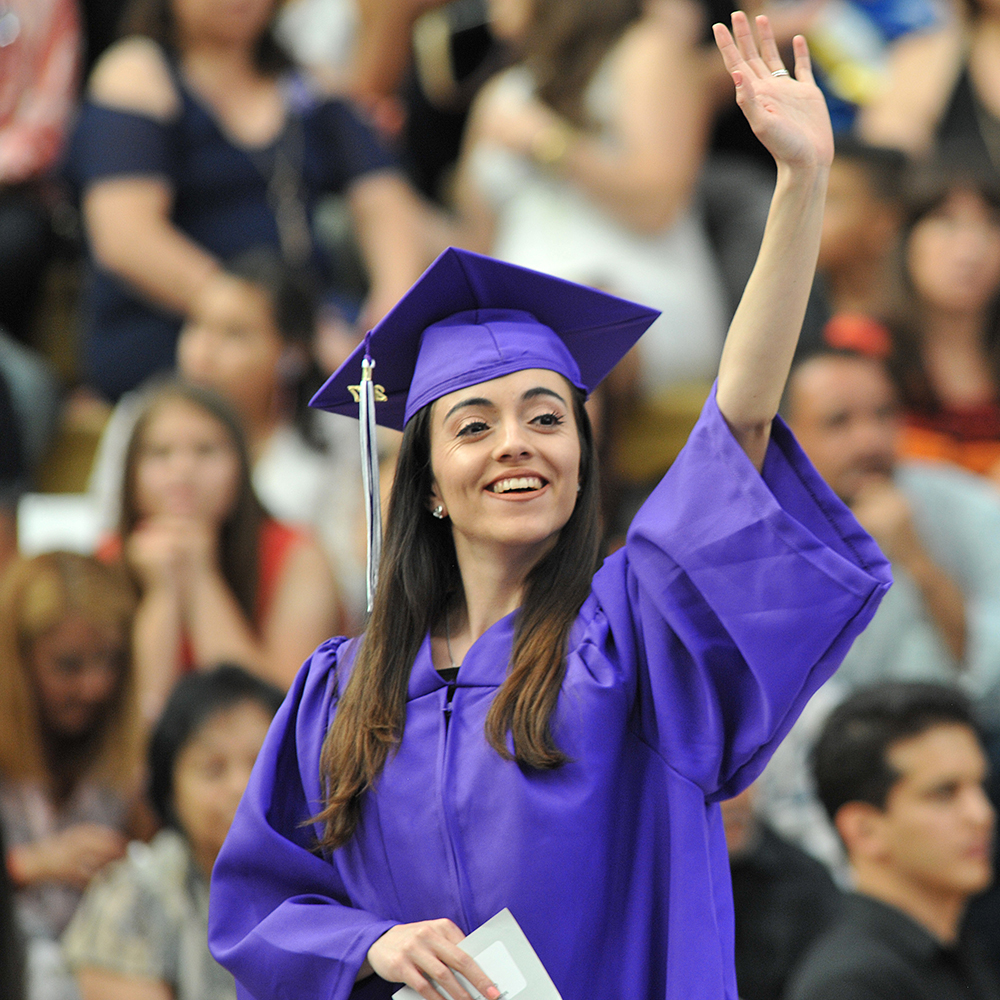 New graduate waving to commencement crowd
