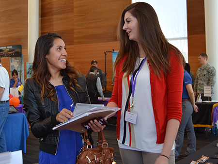 NMHU student speaks to an employer at a Career Fair.