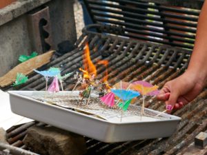 Photo of hands arranging tiny umbrellas in a tray