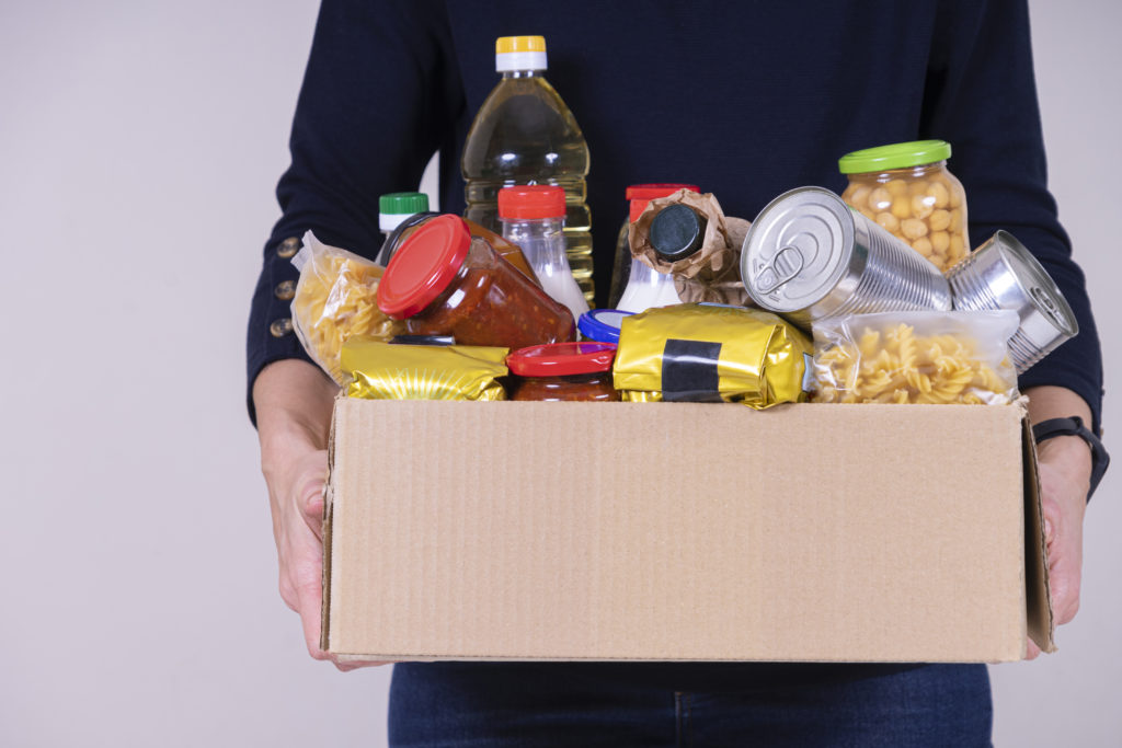 A pair of hands hold a box of food items