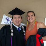 two students posing for a celebration photo during graduation