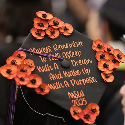 The back of a graduation cap. The text reads "Always remember to fall asleep with a dream and wake up with a purpose. MSW 2025"