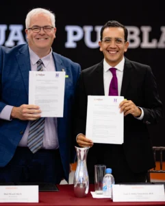 Image of Dr.  Neil Woolf and Mtro. José G. Mata Temoltzin holding signed agreements
