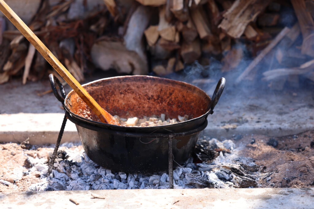 A close up of chicharrónes being cooked in a cast iron pot.