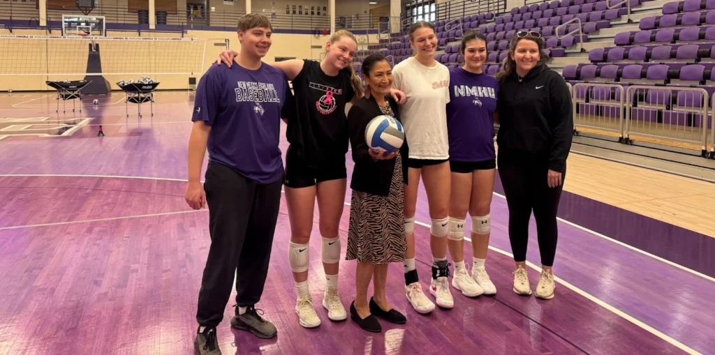 Image of Secretary Deb Haaland with NMHU volleyball coach Meg Grose and players