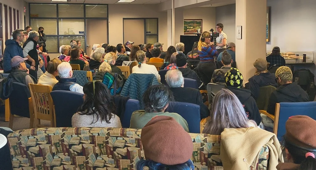 Image of a library room full of people sitting and standing for the presentation by Adelita M. Medina and Dr. Myrriah Gómez