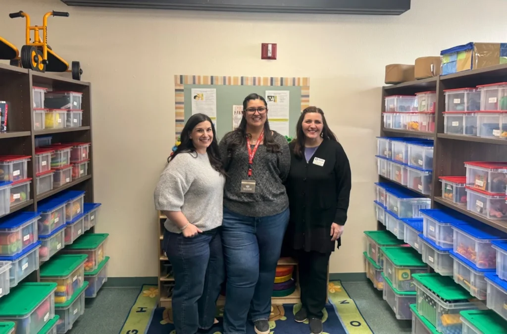 Image of three women standing in the Las Vegas Toy Lending and Resource Library at the NMHU TEC building