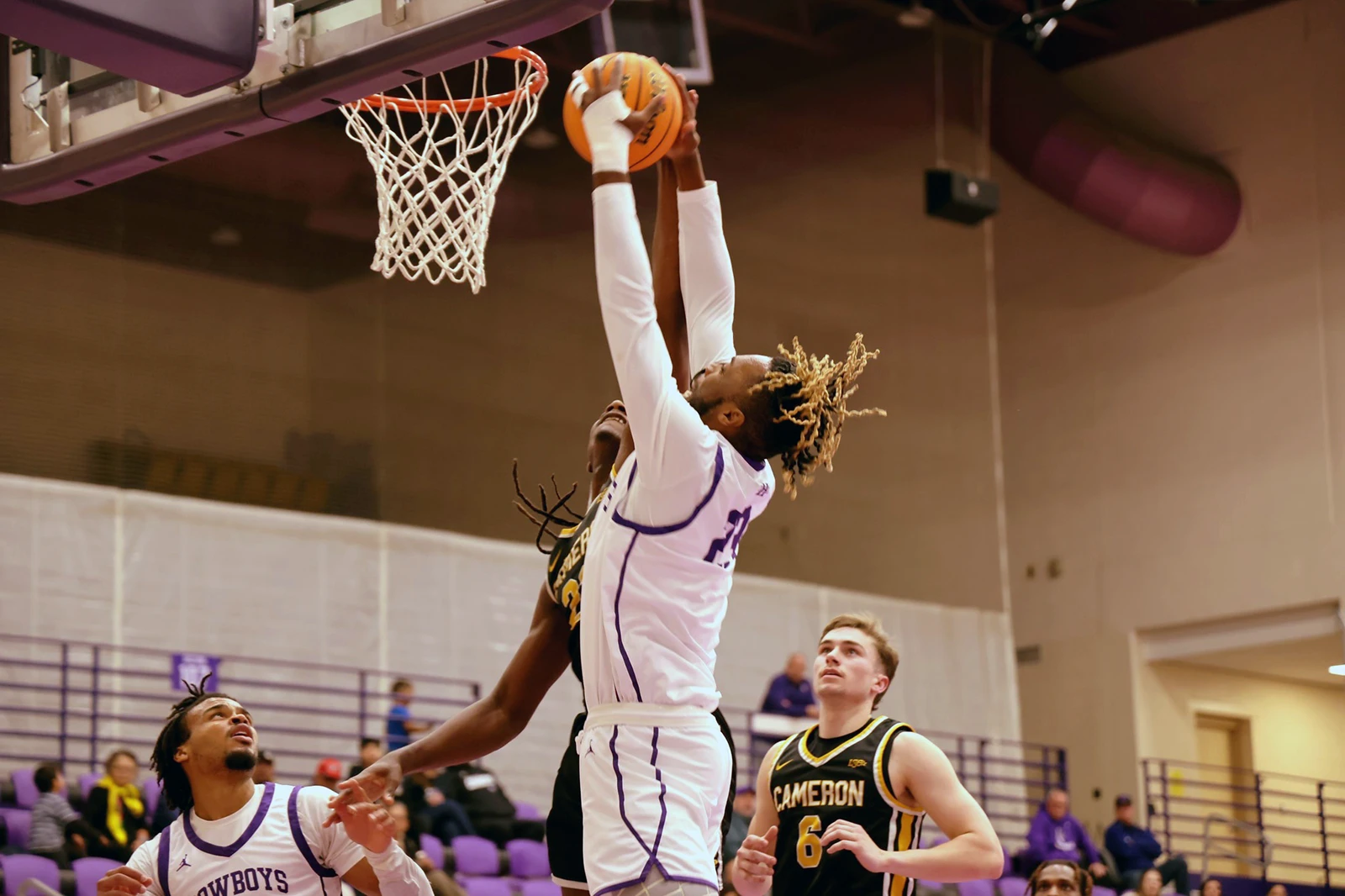 mbb-image-one NMHU men's basketball player jumping to dunk.