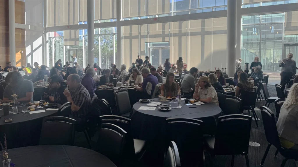 New Mexico Highlands staff members seated at tables in the Student Union Ballroom.