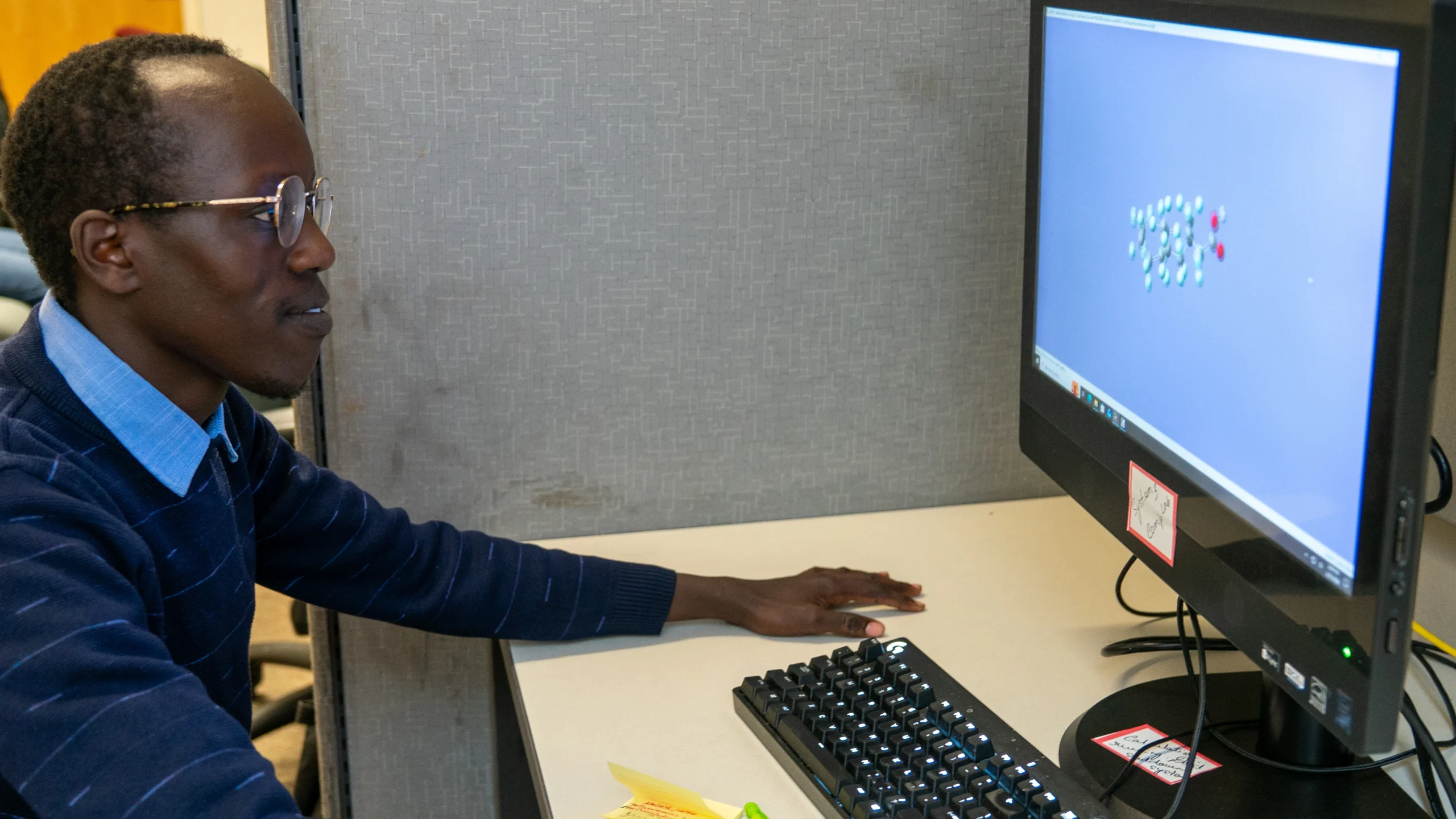 NMHU student James Kurui sits at a computer conducting research.